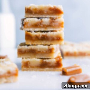 A stack of freshly baked caramel cookie bars, sliced to display a soft and gooey caramel-filled interior, surrounded by a crisp golden crust, rich in flavor.