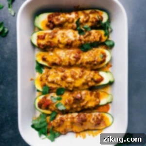 Freshly baked zucchini boats, topped with a delicious meaty sauce and melted cheese, straight out of the oven.