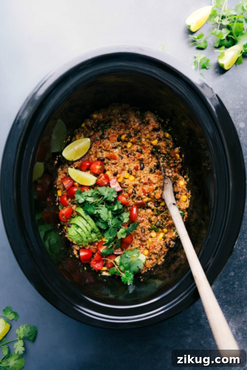 Tex-Mex Quinoa in Crockpot with Spoon and Fresh Toppings A serving of Tex-Mex Quinoa in a crockpot, complete with a spoon and an array of fresh toppings, inviting you to enjoy this delicious meal.