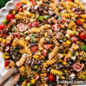 Taco Pasta Salad, a colorful and delicious blend of pasta, seasoned beef, and fresh vegetables, generously coated in creamy dressing.