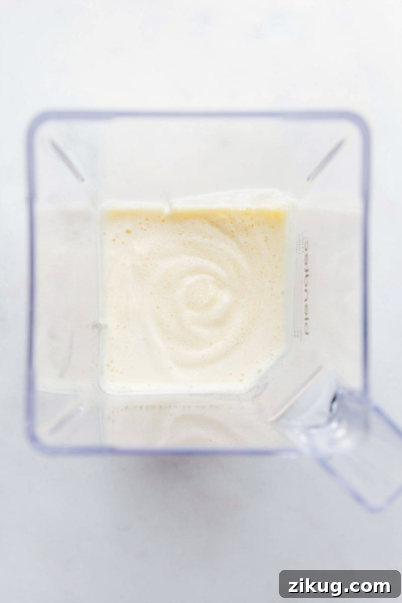 The perfectly blended and frothy Orange Julius still in the blender, showing its smooth, creamy consistency before being poured into glasses.