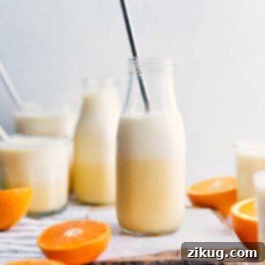 A freshly blended Orange Julius drink in a glass with a straw, ready for serving.