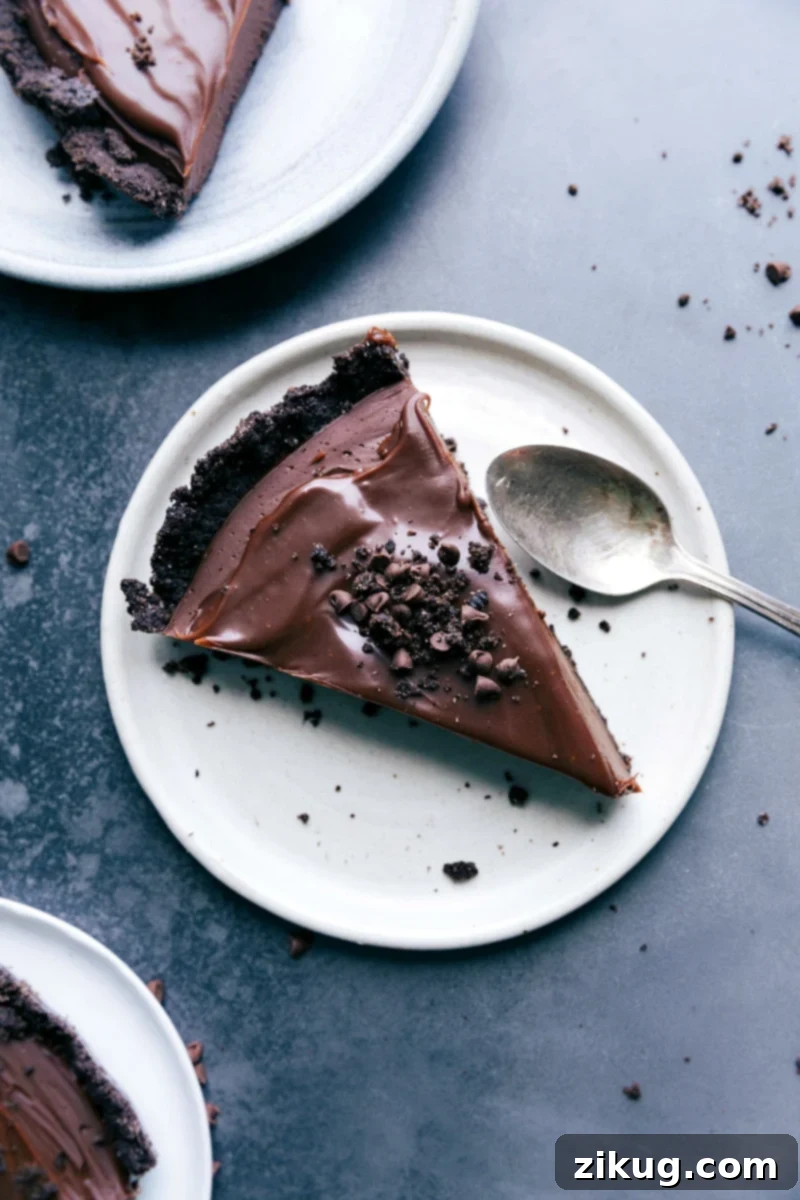 A slice of chocolate tart, a mouthwatering dessert topped with oreo crumbs, ready to be savored.