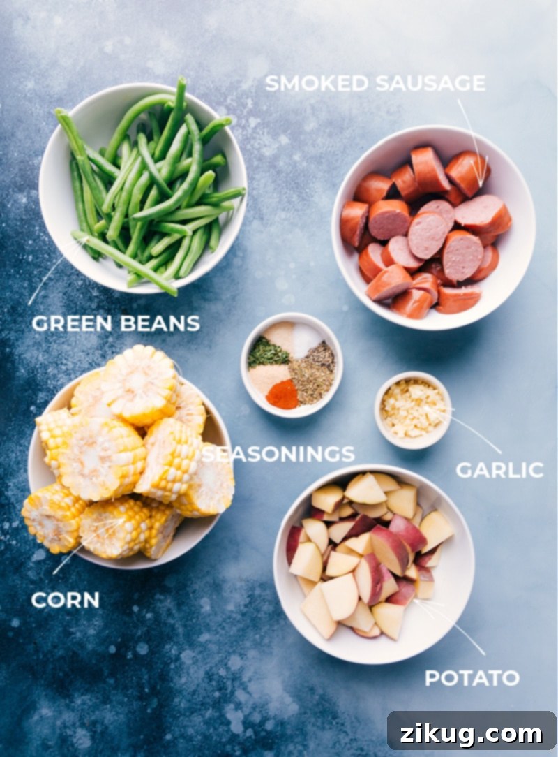 Delicious Foil Pack Garlic Butter Sausage & Veggies: featuring smoked sausage, red potatoes, sweet corn, and crisp green beans. Quick prep for a healthy, easy dinner! #dinner #quick #easy #simple #camping #overfire #grilled #garlicbutter #sausage #veggies #foilpacks Ingredient shot showing all components of the garlic butter sausage and veggie foil pack meal