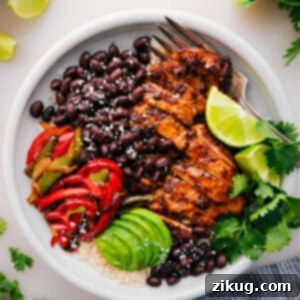 A vibrant Chicken Fajita Bowl overflowing with seasoned chicken, colorful peppers, and fresh toppings.