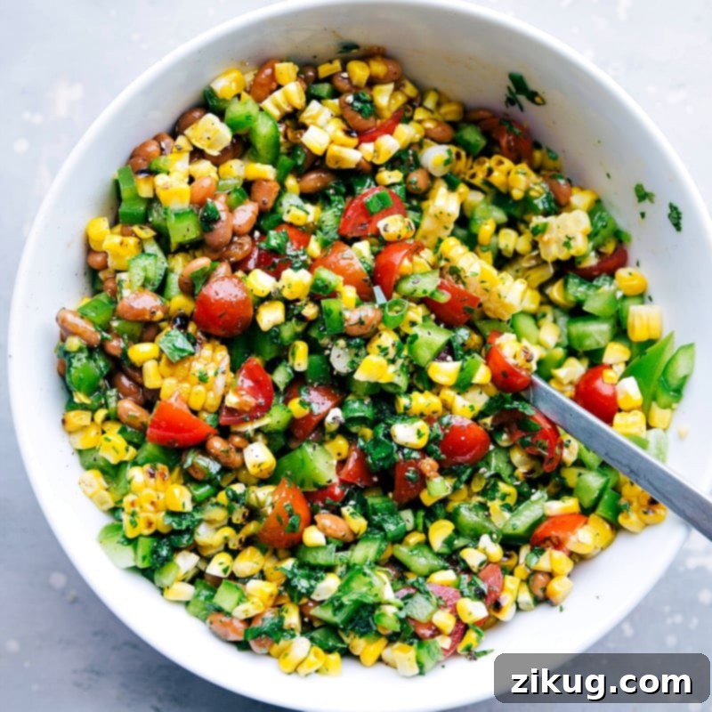 Flavor-Packed Corn Salsa for Burger Side A bowl filled with flavor-packed corn salsa, which serves as a delightful side for this meal, featuring a vibrant blend of ingredients.