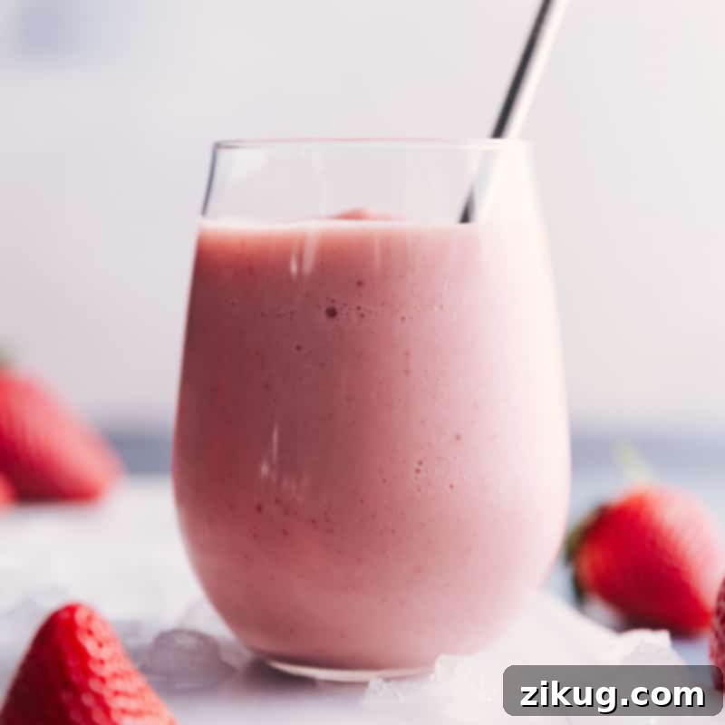 Sip on perfection with this irresistible Jamba Juice Strawberry Wild copycat smoothie recipe – a delightful blend of sweet strawberries and creamy vanilla. A close-up shot of a Jamba Juice Strawberry Wild copycat smoothie in a clear glass, showing its appealing pink color and creamy texture.