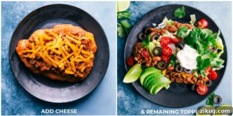 It doesn't get better than these Navajo Tacos that start with the absolute best homemade Fry Bread! The bread is topped with a deliciously seasoned beef and bean mixture and then topped with all your favorite taco toppings like cheese, lettuce, tomatoes, and sour cream. Recipe via ChelseasMessyApron #dinner #quick #easy #simple #best #avocado #toppings #familyfriendly #kidfriendly #frybread #navajo #tacos Close-up process shot showing the final stages of assembling Navajo Tacos, with cheese and additional fresh toppings being added to the warm Fry Bread.