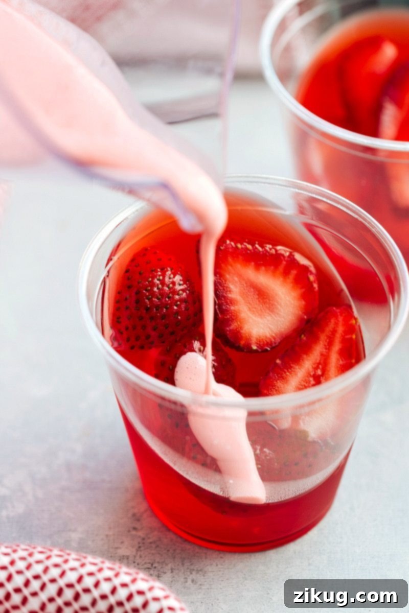 The ingenious and easy method for achieving slanted jell-o parfait cups, topped with a luscious strawberry mousse – a truly delicious and simple recipe.