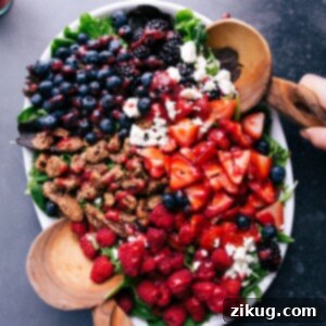 Appetizing salad topped with fresh fruit, cheese, and nuts, ready to be tossed and enjoyed.