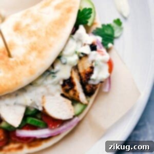 A complete chicken gyro, overflowing with chicken, vegetables, and sauce, wrapped in a soft pita, ready to be enjoyed as part of a chicken gyro recipe.