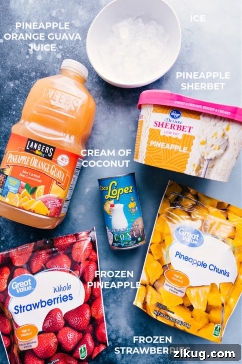 A selection of fresh ingredients laid out for making Strawberry Piña Colada smoothies, including frozen strawberries, frozen pineapple, cream of coconut, pineapple guava juice, and pineapple sherbet.
