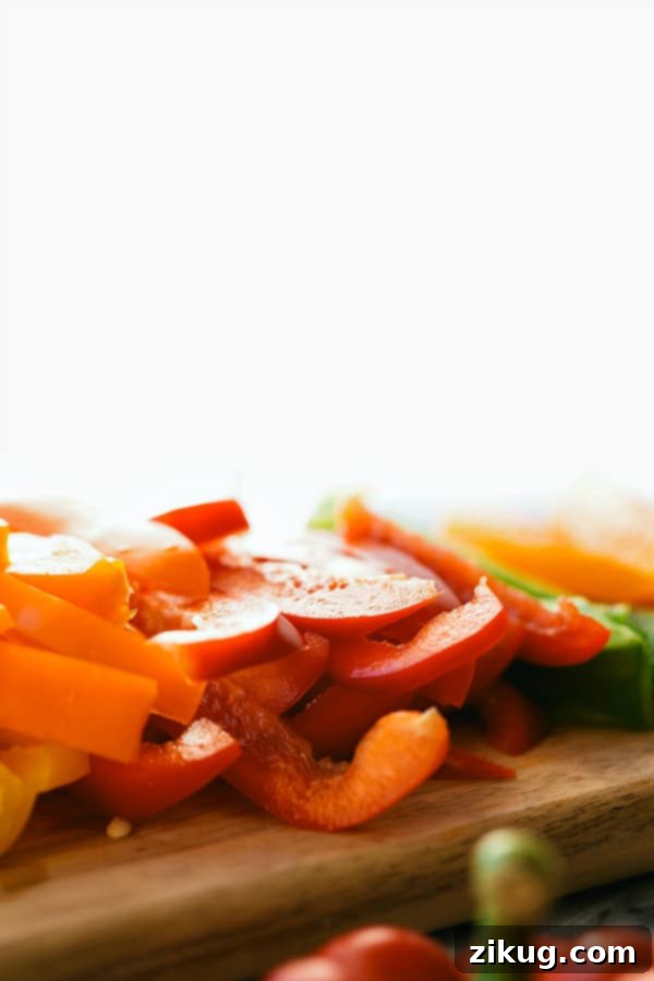 Crispy potatoes, smoked sausage, and colorful vegetables cooking in a skillet for a healthy, easy hash recipe.
