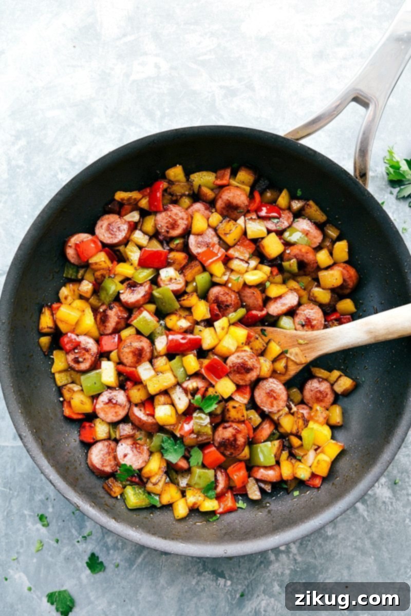 Close-up of a flavorful sausage and vegetable hash, seasoned with herbs and spices, ready to be served.