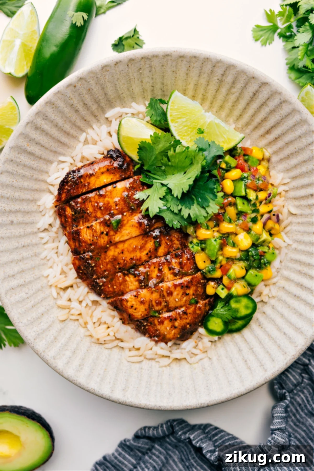 Summer Chicken Recipe: Grilled taco chicken served with a side of avocado salsa, all on a bed of rice.