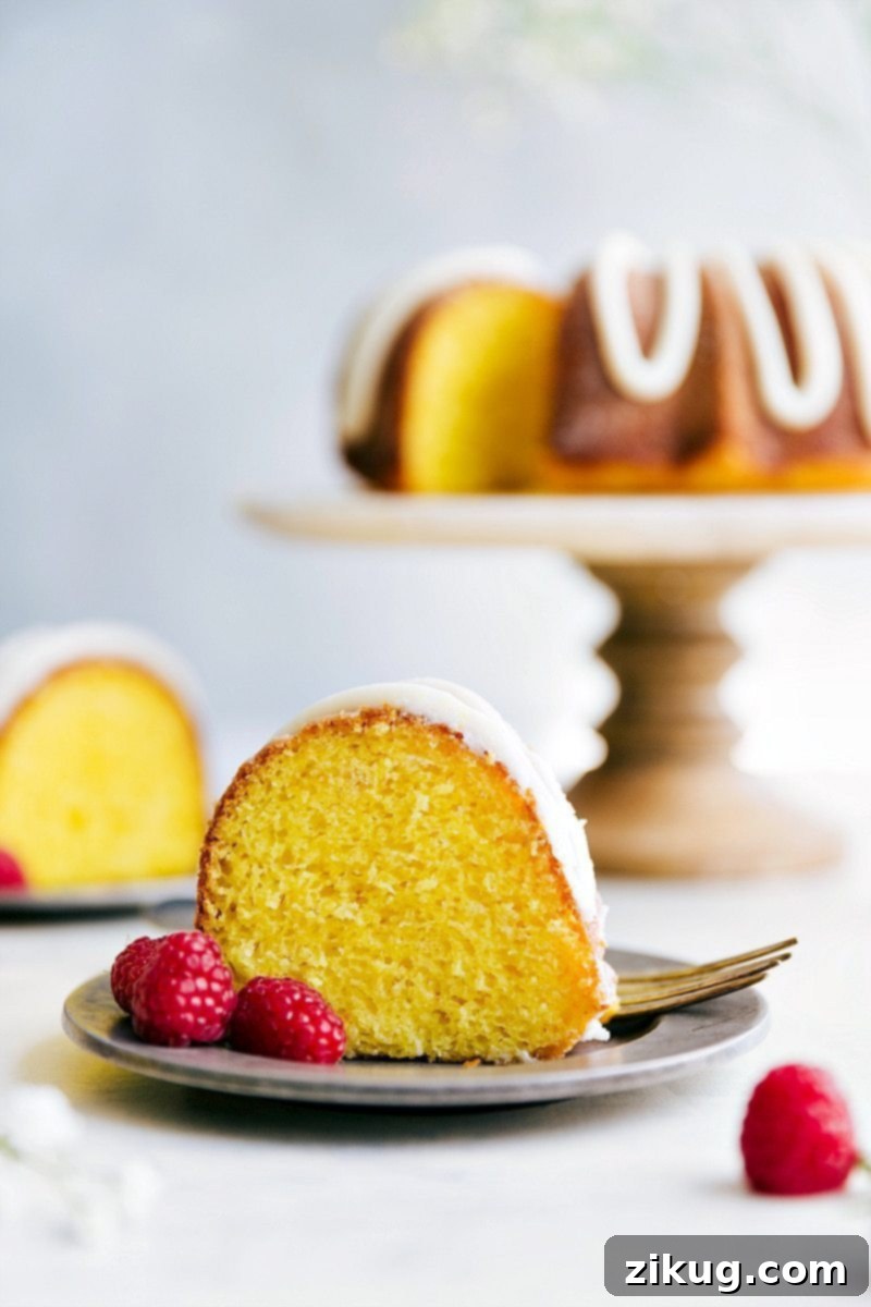 Glazed Lemon Bundt Delight 4 Close-up of a slice of moist lemon bundt cake, revealing its tender crumb and a generous swirl of lemon buttercream frosting. It's the best lemon bundt cake you'll ever bake.
