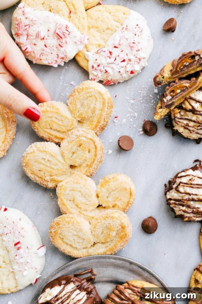 Elegant 3-ingredient Palmiers Christmas cookies! Amazingly delicious and perfect for holiday entertaining. PLUS two free printables for festive packaging. Recipe via chelseasmessyapron #holidays #chocolate #best #quick #easy #simple #3ingredients #christmas #cookies Overhead image of the palmier cookies along with all the other 3-ingredient Christmas cookies