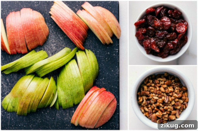 Key Ingredients for Crafting Apple Salad: Apple, Pear, Cranberries, and Walnuts Fresh apple, pear, dried cranberries, and walnuts, key ingredients for the apple salad recipe.