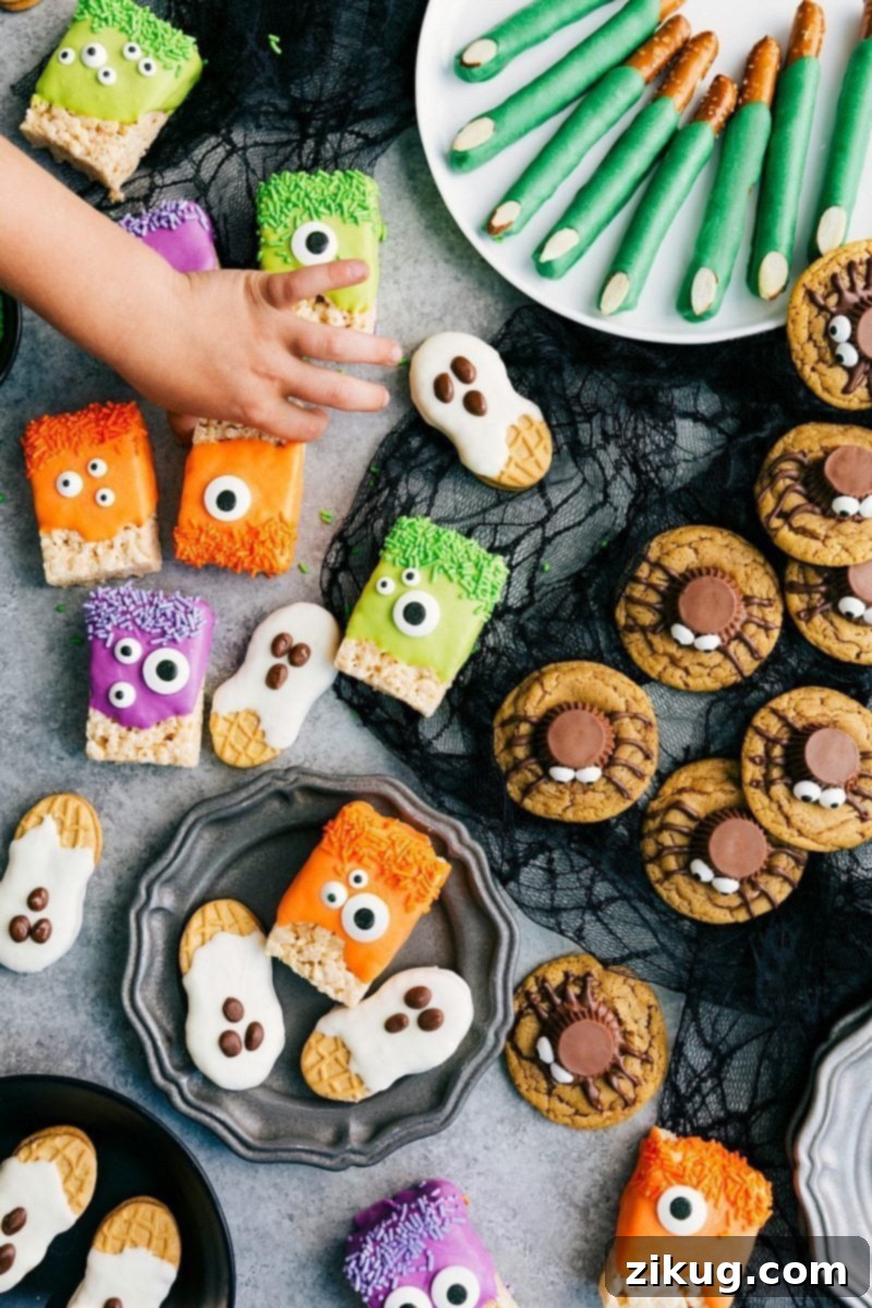 A vibrant assortment of easy 3-ingredient Halloween treats: green Monster Rice Krispies, classic Peanut Butter Spider Cookies, white Nutter Butter Ghosts, and eerie Witch Finger Pretzels.