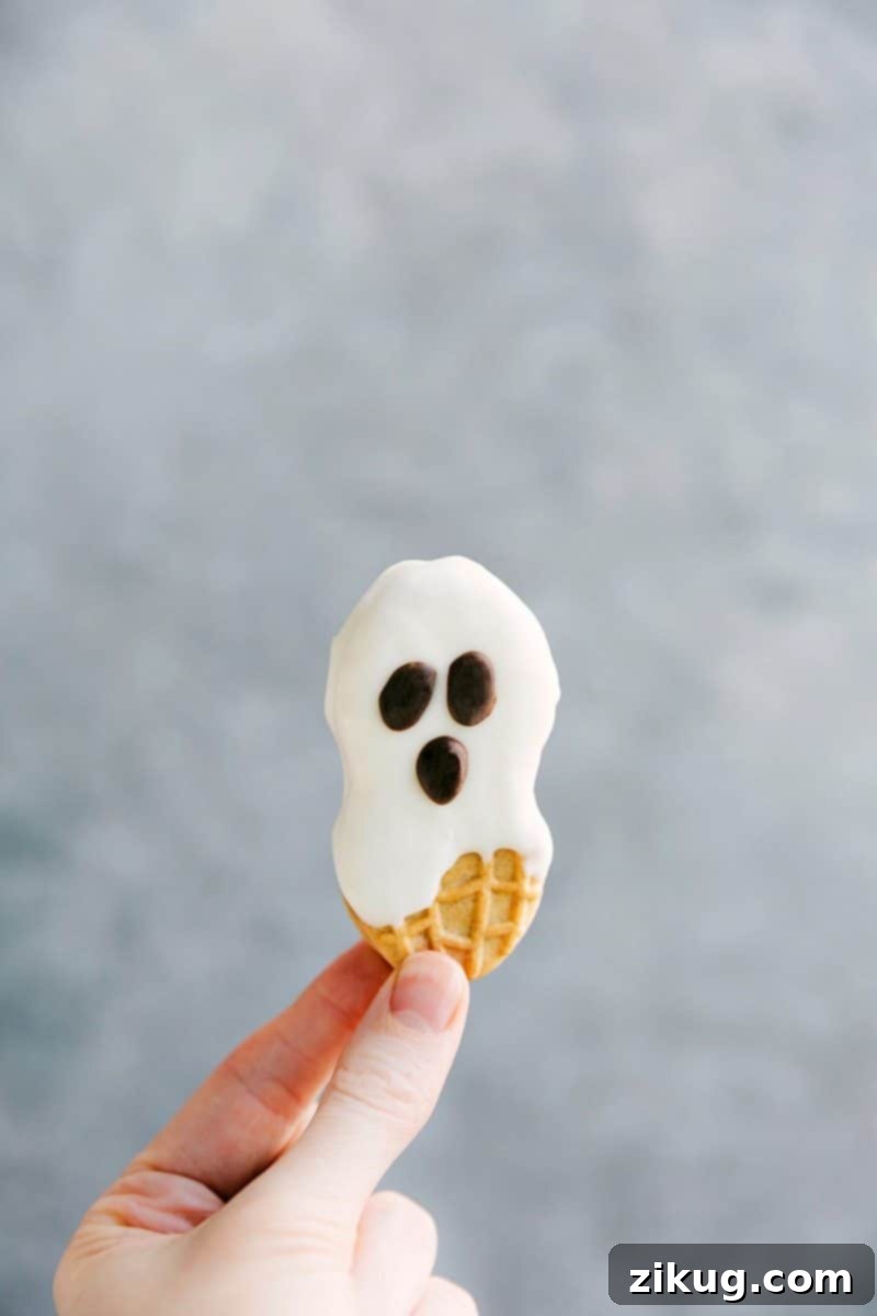 Adorable Nutter Butter ghost cookies with white chocolate coating and cute chocolate chip faces, ideal for simple Halloween treats.