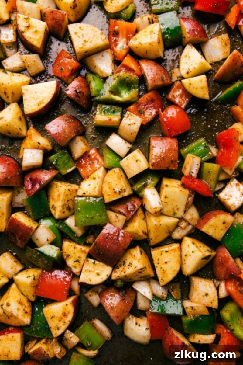 Easy One Pan Bacon and Potatoes 5 Crispy bacon strips baking on a sheet pan in the oven, rendering their flavorful fat before vegetables are added.