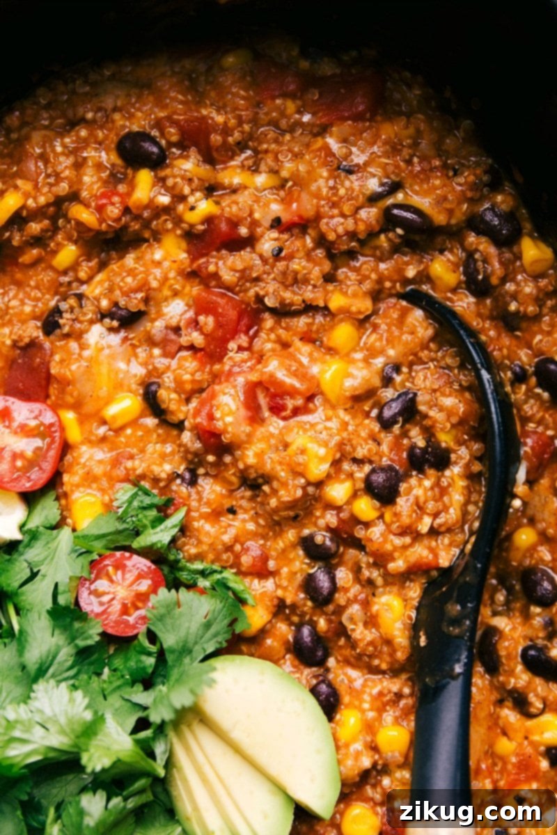 Hearty Enchilada Quinoa Crockpot Meal Ready to Enjoy Finished enchilada quinoa dish in a crockpot, rich and flavorful, with a spoon nestled inside, ready for serving.
