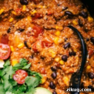 Crockpot Quinoa Enchilada Bake 2 Finished enchilada quinoa dish in a crockpot, rich and flavorful, with a spoon nestled inside, ready for serving.