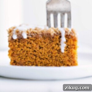 Delicious slice of pumpkin coffee cake with icing on top ready to be enjoyed.