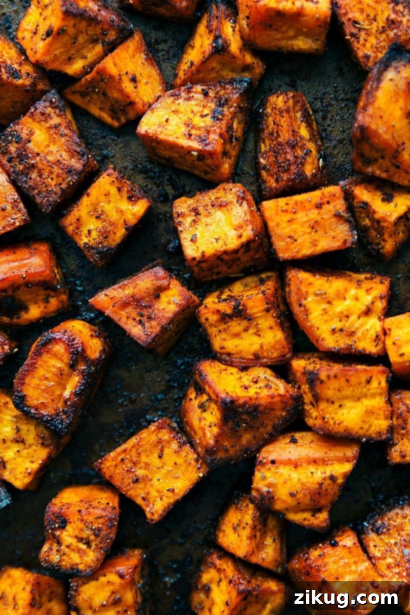 Sweet Potato Power Bowl 4 Close-up shot of vibrant sweet potato taco bowls, showcasing perfectly roasted sweet potatoes, dark black beans, bright corn, and fresh green cilantro.