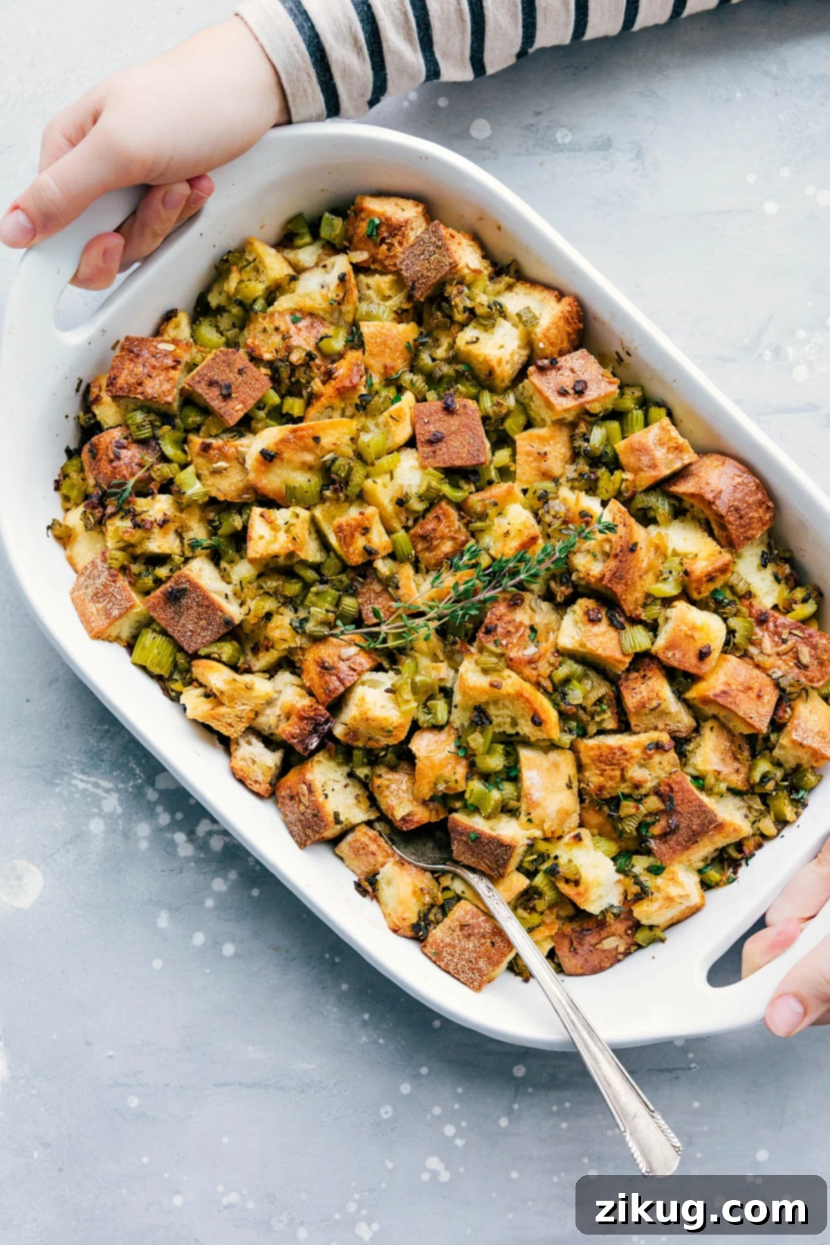 A golden-brown Thanksgiving dressing, baked to perfection in a ceramic casserole dish, ready to be served.