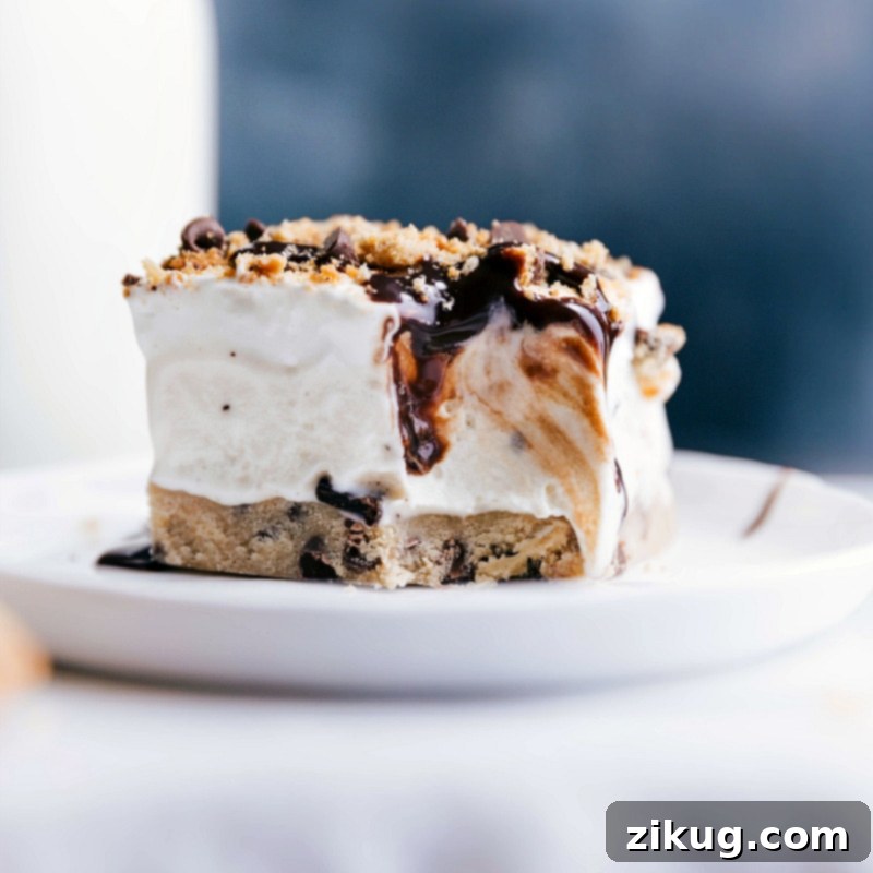 Indulgent Cookie Dough Ice Cream Bar with Whipped Cream and Chocolate - Irresistible Bite Taken Bitten cookie dough ice cream bar with chocolate and whipped cream swirls visible, tempting and indulgent.