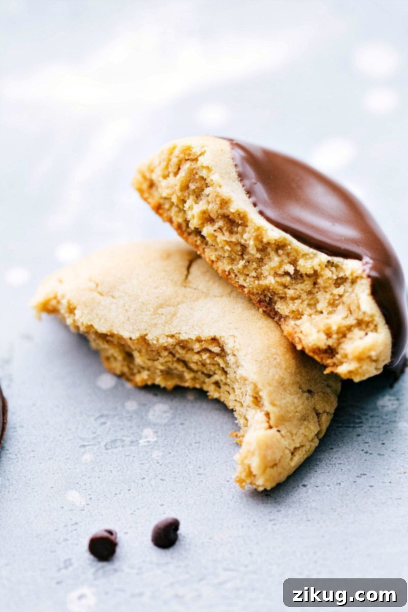 The perfect cross-section of our favorite Peanut Butter Cookie, showcasing its incredible softness and chewiness. A perfectly baked peanut butter cookie, artfully split in half to reveal its soft, chewy interior and rich texture.