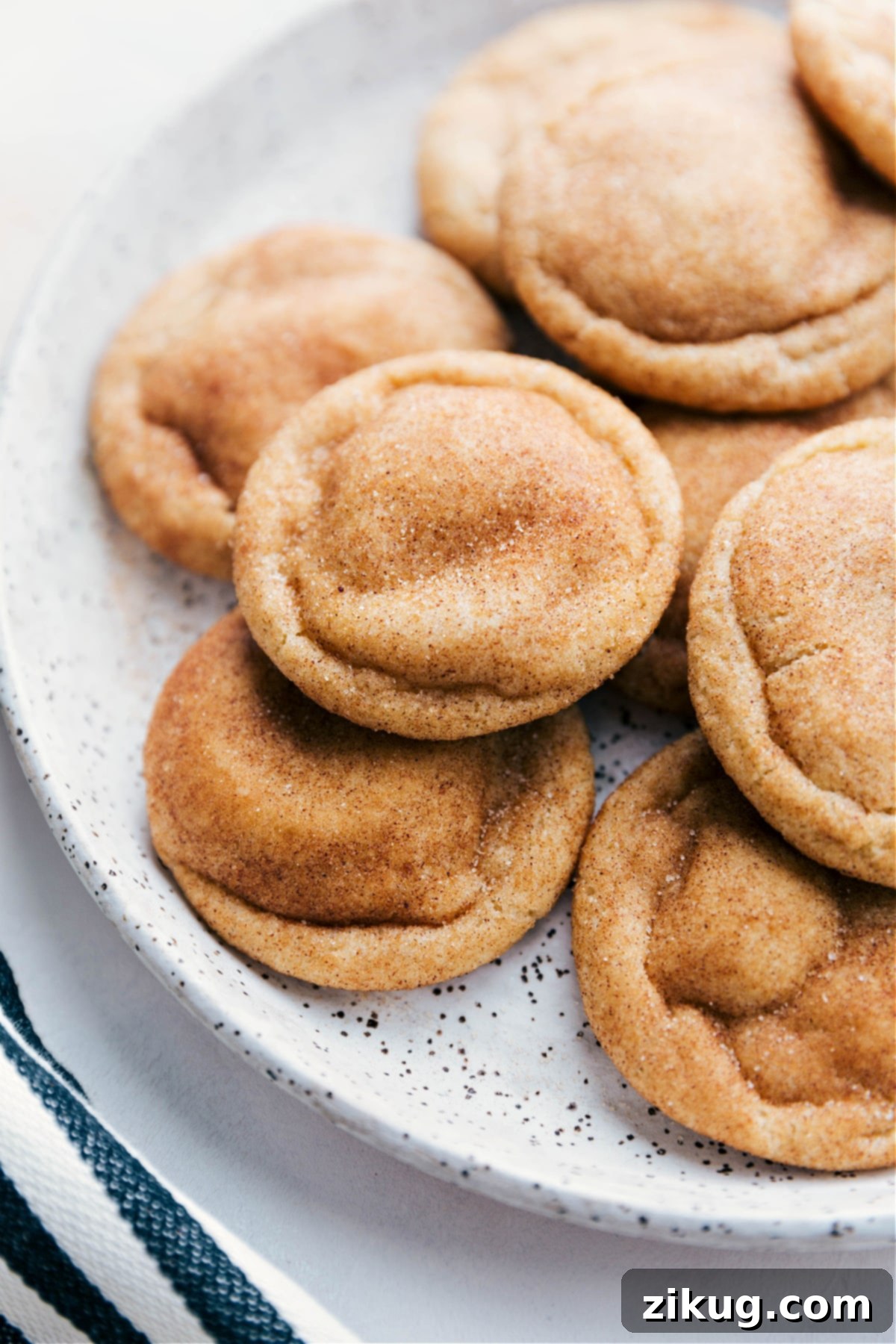 Freshly Baked Snickerdoodle Cookies Snickerdoodle cookies arranged on a plate, fresh out of the oven, warm and inviting with a golden-brown exterior, dusted with cinnamon sugar, and packed with the best flavor.
