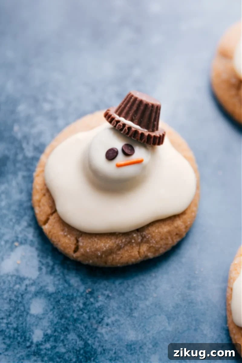 Overhead image of beautifully decorated Melted Snowman Cookies on a festive platter, showcasing the melted white chocolate and candy details.