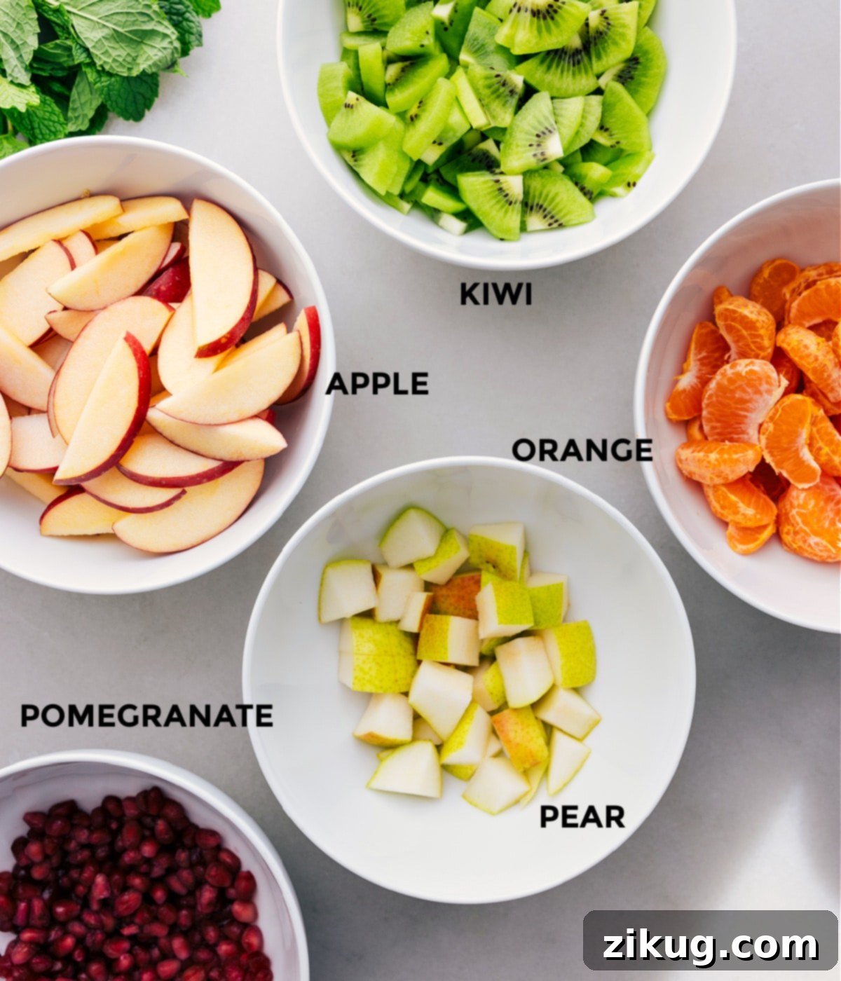 Ingredients In Winter Fruit Salad All the ingredients for this vibrant winter fruit salad are prepped for easy assembly, including brightly colored kiwis, crisp apples, juicy oranges, firm pears, and glistening pomegranates.