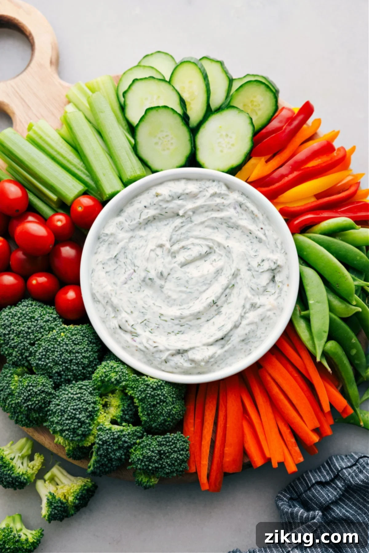 Easy And Delicious Vegetable Dip Recipe For Hosting A festive platter showcasing a central bowl of creamy veggie dip, artfully surrounded by an assortment of fresh, colorful vegetables, perfect for easy hosting and healthy snacking.