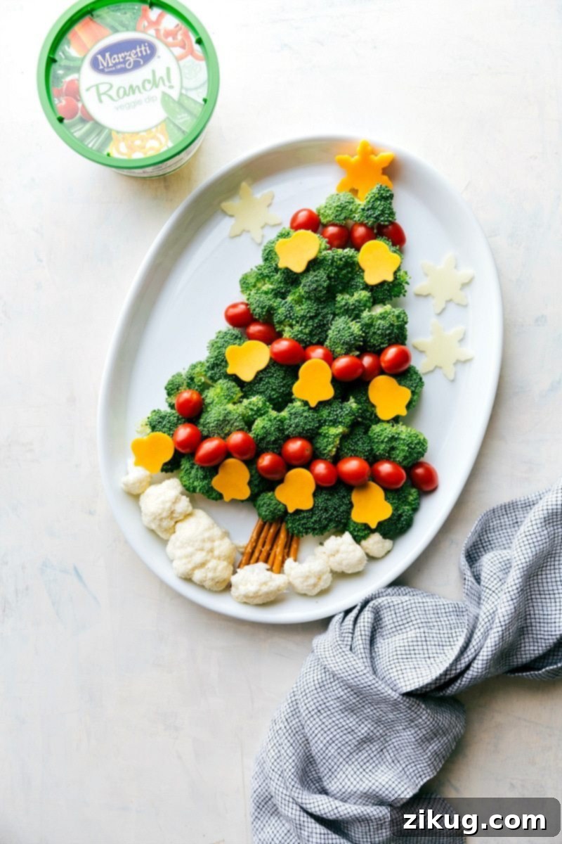 Christmas Tree Veggie Dip Recipe for Holidays A delightful Christmas tree-shaped vegetable platter with a central bowl of veggie dip, making a festive and healthy holiday snack.