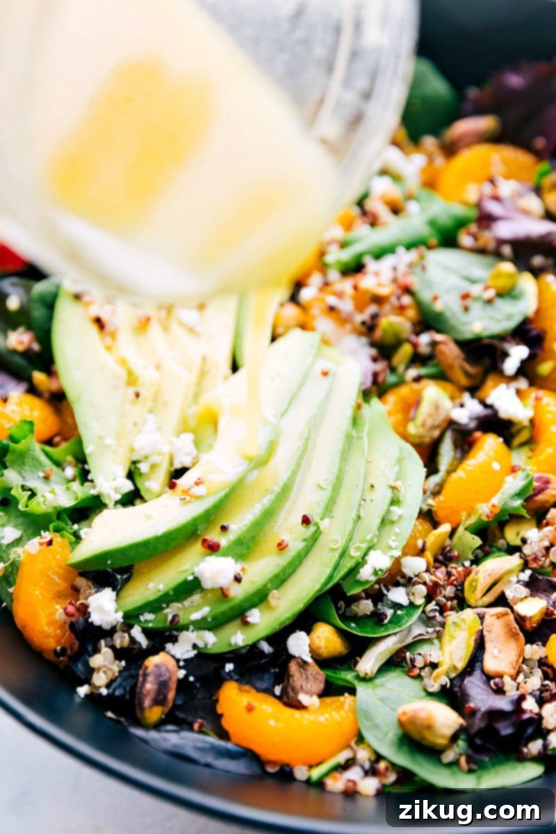 Close-up image of the tangy citrus vinaigrette being poured over the vibrant Citrus Quinoa Salad, highlighting its fresh appeal.