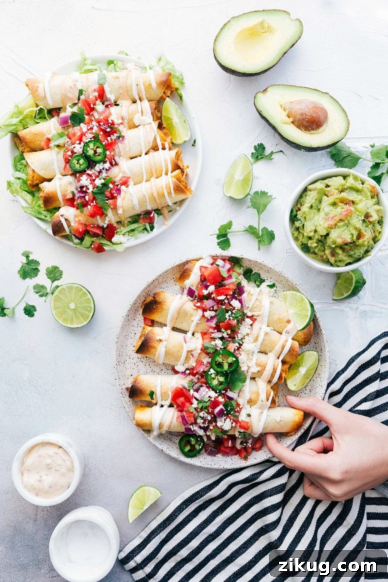 Crispy Baked Chicken Taquitos 5 A plate full of freshly baked chicken taquitos, garnished with fresh cilantro and ready to be served.
