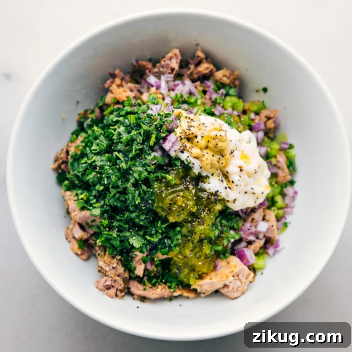 Delicious Tuna Salad in a Bowl The absolute best homemade creamy tuna salad, freshly prepared and served beautifully in a classic white bowl, garnished with a sprig of fresh parsley, ready to be enjoyed as a meal.