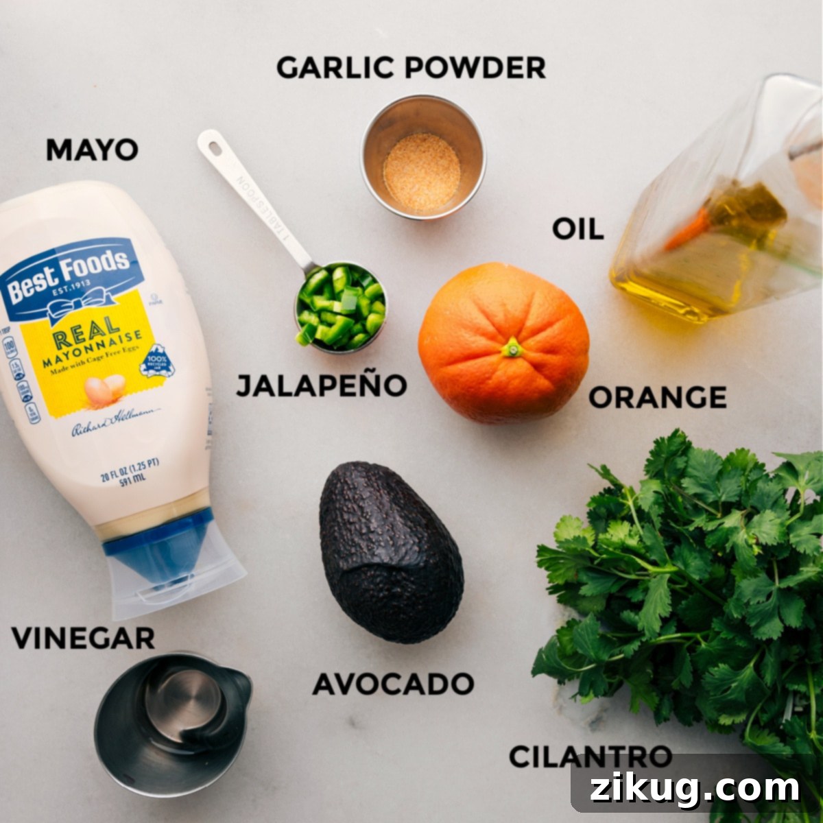 Ingredients In The Best Dressing Close-up of fresh ingredients for the Mojo sauce, including a ripe avocado, orange, jalapeño, cilantro, and mayonnaise, meticulously prepped and ready for blending.