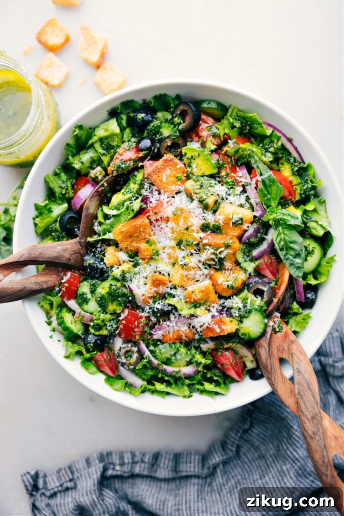 Best Italian Salad Recipe with Homemade Dressing A large bowl of fresh Italian Salad, vibrant with colorful vegetables and dressing, ready to be served on a rustic wooden table.