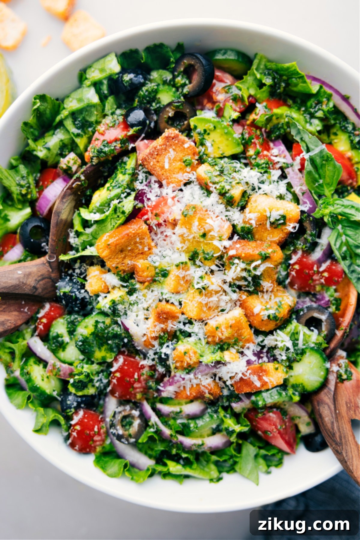 Delicious & Healthy Italian Salad Recipe A vibrant, fully dressed Italian Salad in a large serving bowl, garnished with croutons and ready to be enjoyed, presented on a light background.