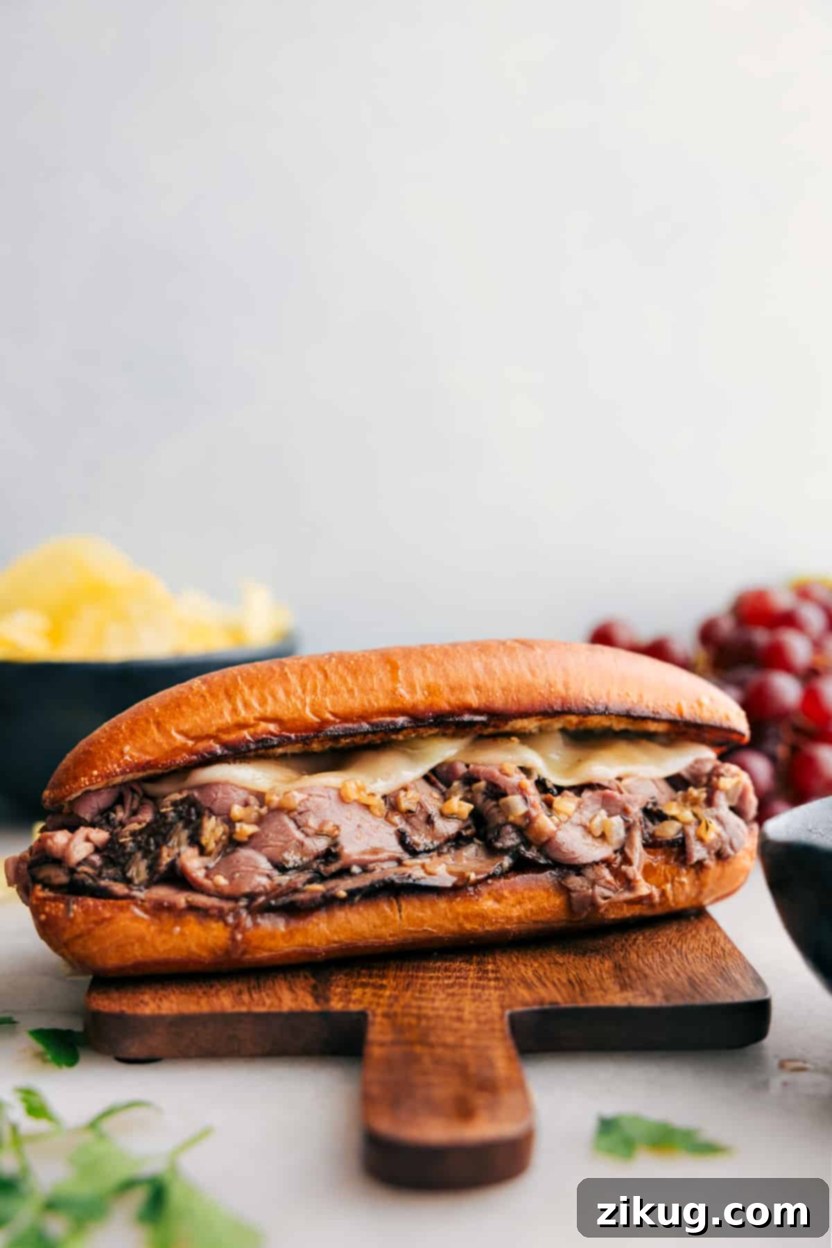 The Best Easy French Dip Sandwiches Recipe for Quick Weeknight Dinners Easy and melty French Dip Sandwiches ready to be enjoyed, showcasing golden toasted buns, generous portions of tender roast beef, and perfectly melted cheese, with small bowls of rich au jus on the side for dipping.
