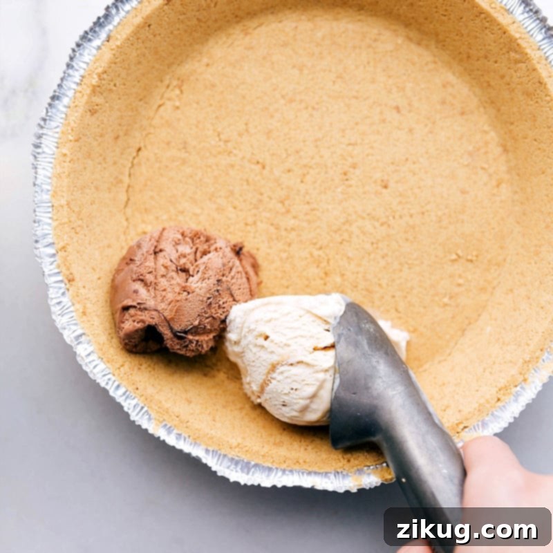 Scooping Ice Cream into Crust Various scoops of chocolate and caramel ice cream being artfully layered into a golden-brown graham cracker crust, showcasing the preparation process before freezing.