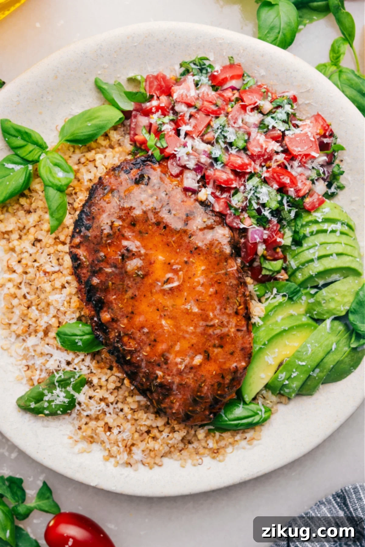 The Ultimate Bruschetta Chicken Recipe Bruschetta Chicken on a bed of quinoa with fresh bruschetta and avocado on the side. A perfectly grilled chicken breast, vibrant tomatoes, fresh basil, and creamy avocado create an inviting meal.