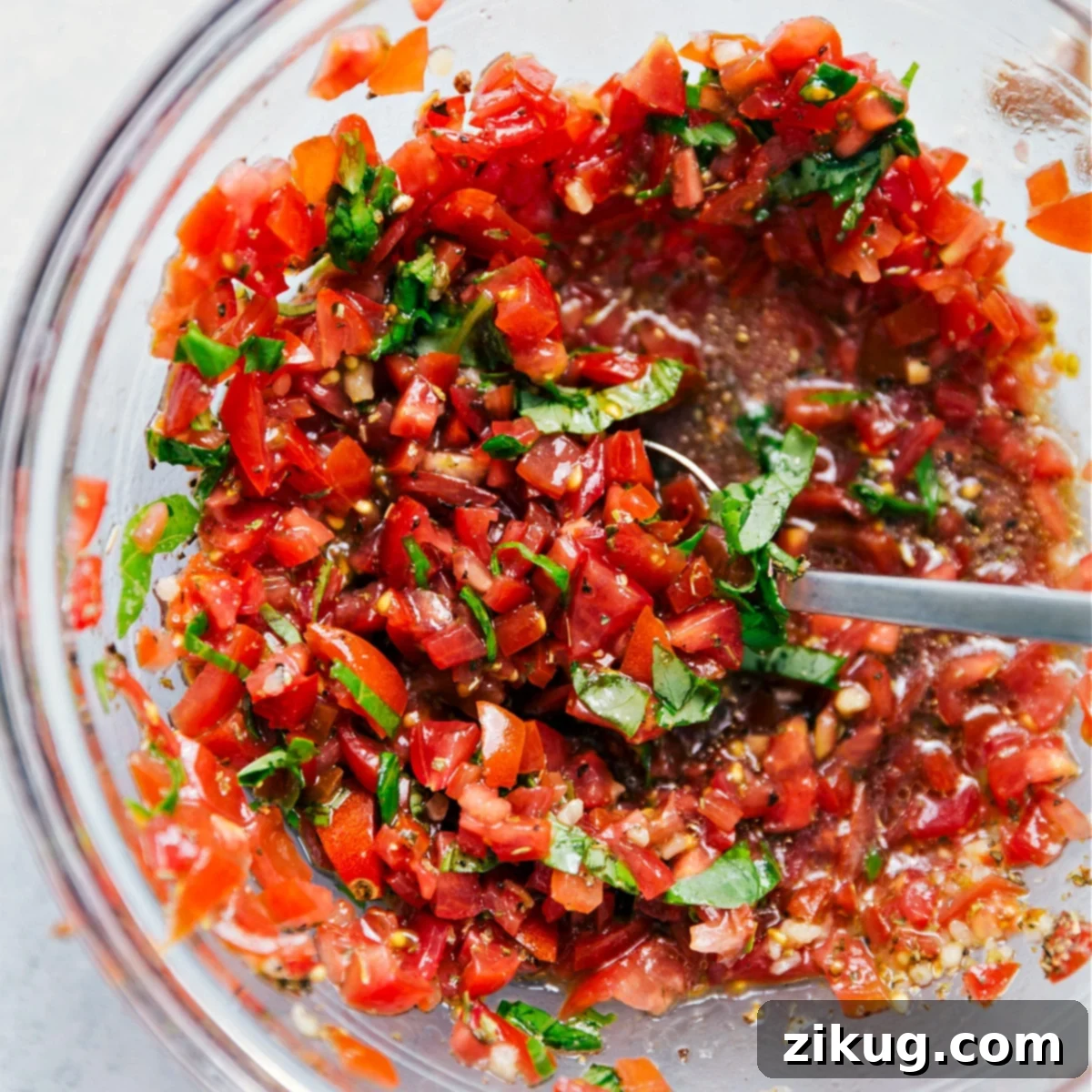 The Best Homemade Bruschetta Topping The fresh bruschetta in a bowl, showcasing vibrant diced tomatoes, green basil, and minced garlic and onion, ready to go with this dish.