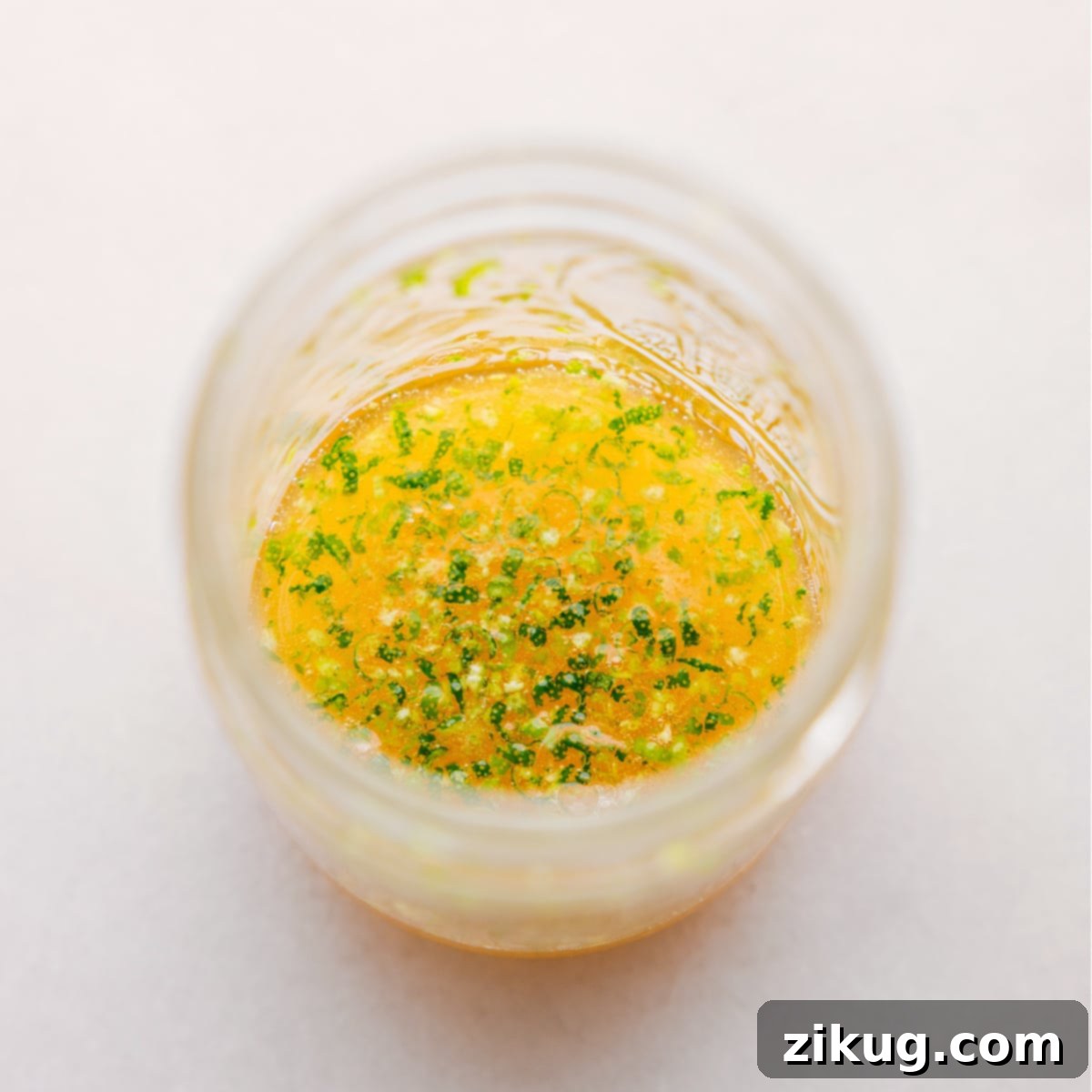 Refreshing Tropical Fruit Salad with Simple Three Ingredient Dressing 4 A small glass jar filled with the vibrant honey-lime dressing, ready to be drizzled over the fruit salad.