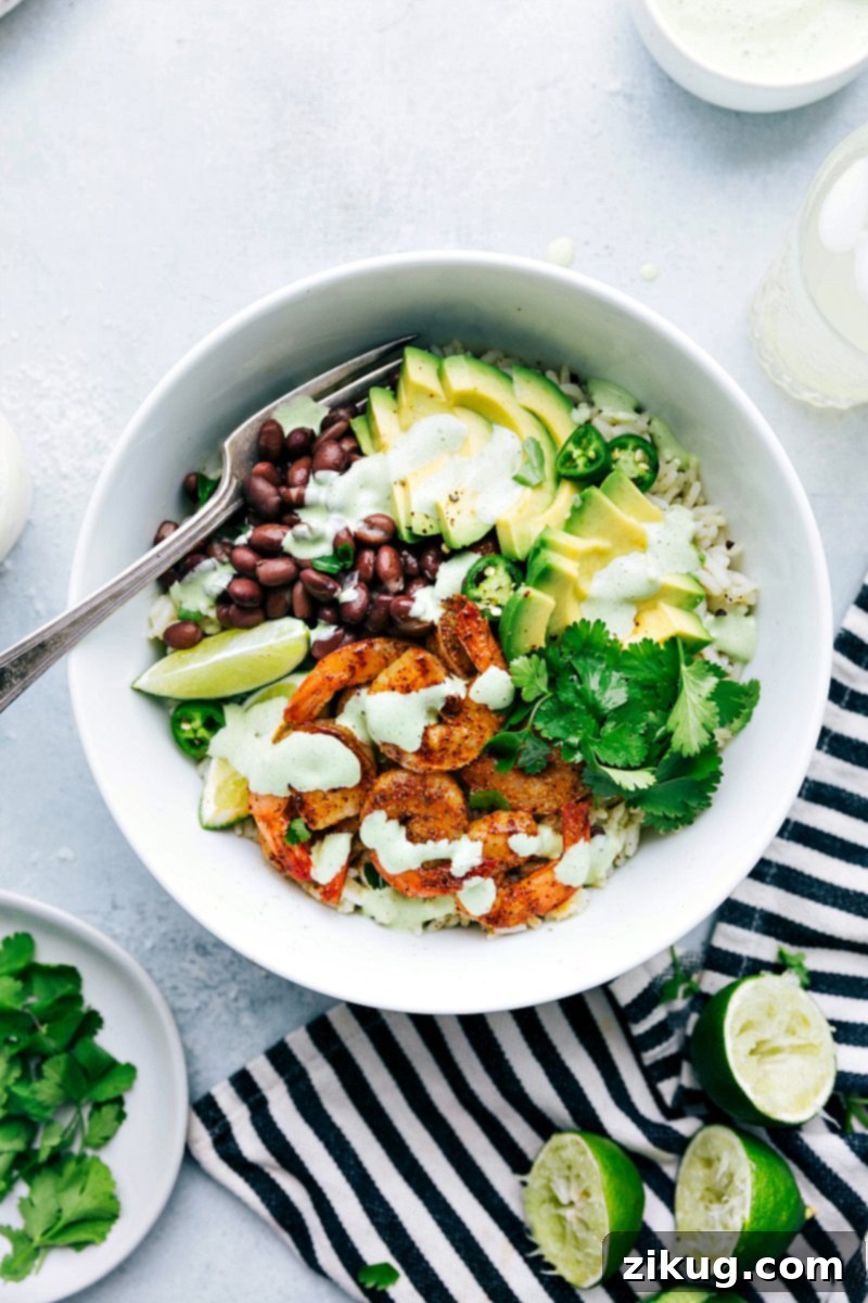 A perfectly assembled Cilantro Lime Shrimp bowl, garnished and ready to be savored, highlighting the fresh ingredients and vibrant colors. Up-close overhead image of the Cilantro Lime Shrimp bowl ready to be served, garnished with fresh cilantro and lime wedges