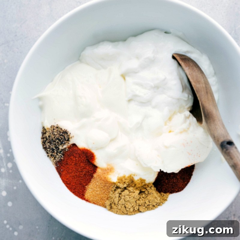 Seasonings and sour cream added to a bowl, ready to be mixed together.